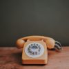 Ein altes Telefon mit angedeuteter Wählscheibe und kabelgebundenem Hörer